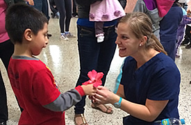 child giving volunteer a flower