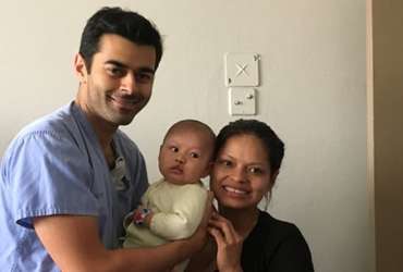 volunteer with mom and baby post surgery