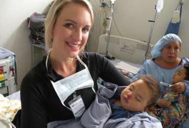 volunteer holding baby post-surgery